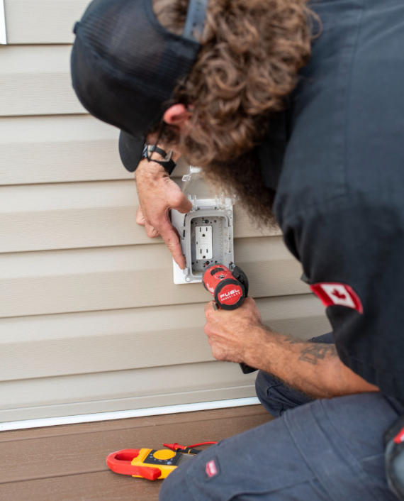 Electrician installing an exterior outlet in Markham